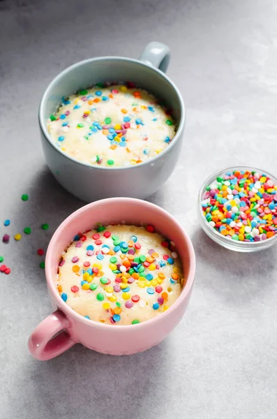 Funfetti Mug Cake, Homemade Cake Cooked in the Microwave on Bright Background