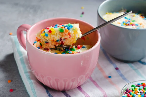 Funfetti Mug Cake, Homemade Cake Cooked in the Microwave on Bright Background