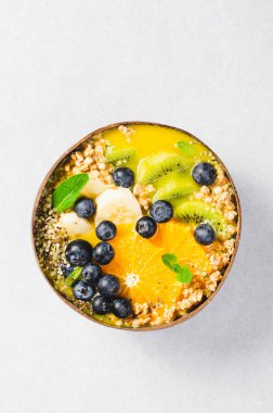 Hindistancevizi kasesinde Orange, Kiwi, Blueberry ve Granola ile Smoothie Bowl, Sağlıklı Yemek, Vegan veya Vejetaryen Beslenme Konsepti