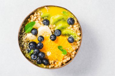 Hindistancevizi kasesinde Orange, Kiwi, Blueberry ve Granola ile Smoothie Bowl, Sağlıklı Yemek, Vegan veya Vejetaryen Beslenme Konsepti