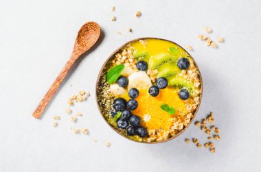 Hindistancevizi kasesinde Orange, Kiwi, Blueberry ve Granola ile Smoothie Bowl, Sağlıklı Yemek, Vegan veya Vejetaryen Beslenme Konsepti
