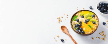 Hindistancevizi kasesinde Orange, Kiwi, Blueberry ve Granola ile Smoothie Bowl, Sağlıklı Yemek, Vegan veya Vejetaryen Beslenme Konsepti