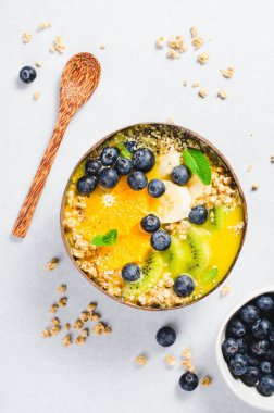 Hindistancevizi kasesinde Orange, Kiwi, Blueberry ve Granola ile Smoothie Bowl, Sağlıklı Yemek, Vegan veya Vejetaryen Beslenme Konsepti