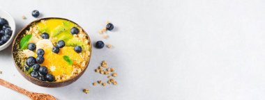 Hindistancevizi kasesinde Orange, Kiwi, Blueberry ve Granola ile Smoothie Bowl, Sağlıklı Yemek, Vegan veya Vejetaryen Beslenme Konsepti