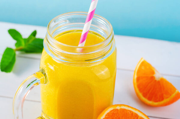 Orange Smoothie in a Jar, Vitamin Drink or Refreshing Cocktail on Bright Background