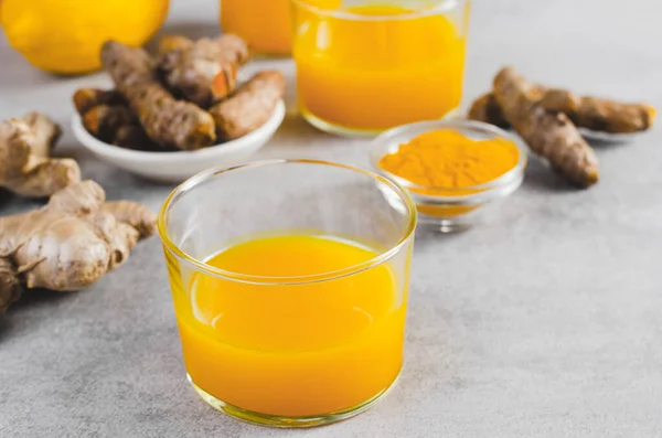 采购产品姜黄射击 健康的饮料与姜黄和香料 Jamu果汁 免疫助推器饮料在明亮的灰色背景 — 图库照片