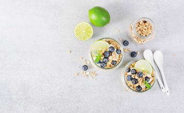 Yoğurt, kireç ve yaban mersinli gevrek, sağlıklı atıştırmalık veya Parlak Arkaplanda Kahvaltı