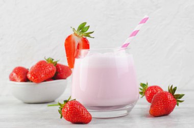 Çilekli içecek, milkshake ve açık gri arka planda taze çilek.