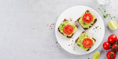 Domatesli Avokado Tostları, Sağlıklı Atıştırmalıklar ya da Açık Gri Arkaplanda Kahvaltı