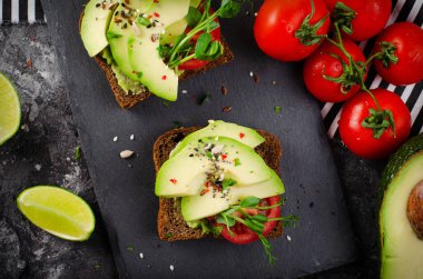 Domatesli Avokado Tostları, Sağlıklı Atıştırmalıklar veya Siyah Arkaplanda Kahvaltı
