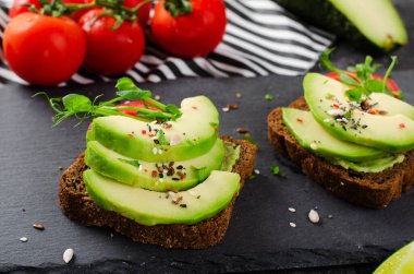 Domatesli Avokado Tostları, Sağlıklı Atıştırmalıklar veya Siyah Arkaplanda Kahvaltı
