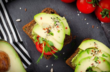Domatesli Avokado Tostları, Sağlıklı Atıştırmalıklar veya Siyah Arkaplanda Kahvaltı