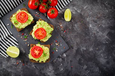 Domatesli Avokado Tostları, Sağlıklı Atıştırmalıklar veya Siyah Arkaplanda Kahvaltı