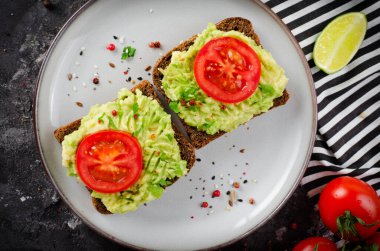 Domatesli Avokado Tostları, Sağlıklı Atıştırmalıklar veya Siyah Arkaplanda Kahvaltı