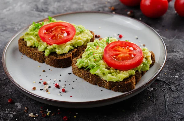 stock image Avocado Toasts with Tomato, Healthy Snack or Breakfast on Dark Black Background