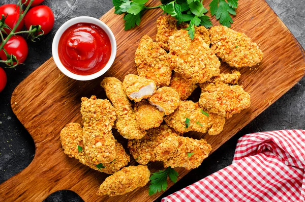 Delicious Crispy Fried Breaded Chicken Breast Strips with Ketchup on Dark Background, Chicken Fingers