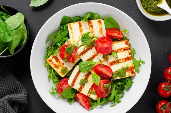 stock image Grilled Halloumi Cheese with Cheery Tomatoes and Pesto with Arugula, Spinach, and Basil, Ketogenic Paleo Diet Lunch, Healthy Easting