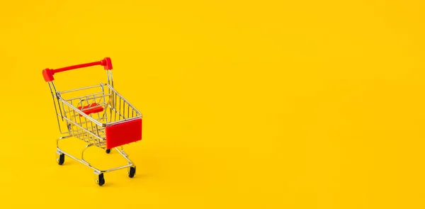 黄色の背景にショッピングカートやトロリー ショッピング 販売コンセプト — ストック写真