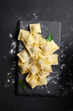 Unlu çiğ Ravioli ve Karanlık Arkaplanda Basil, Taze İtalyan Ravioli