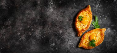 Ajarian Khachapuri, peynirle dolu ve yumurta sarısı ile kaplanmış, geleneksel Gürcistan Khachapuri peynirli ekmek ile Karanlık Kırsal Arka plan