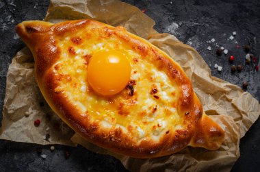 Ajarian Khachapuri, peynirle dolu ve yumurta sarısı ile kaplanmış, geleneksel Gürcistan Khachapuri peynirli ekmek ile Karanlık Kırsal Arka plan