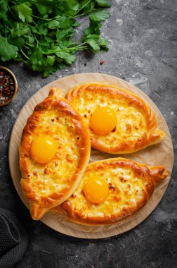 Ajarian Khachapuri, peynirle dolu ve yumurta sarısı ile kaplanmış, geleneksel Gürcistan Khachapuri peynirli ekmek ile Karanlık Kırsal Arka plan