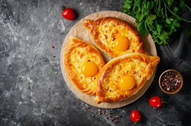 Ajarian Khachapuri, peynirle dolu ve yumurta sarısı ile kaplanmış, geleneksel Gürcistan Khachapuri peynirli ekmek ile Karanlık Kırsal Arka plan