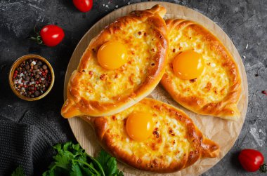 Ajarian Khachapuri, peynirle dolu ve yumurta sarısı ile kaplanmış, geleneksel Gürcistan Khachapuri peynirli ekmek ile Karanlık Kırsal Arka plan