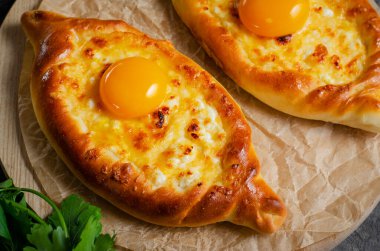 Ajarian Khachapuri, peynirle dolu ve yumurta sarısı ile kaplanmış, geleneksel Gürcistan Khachapuri peynirli ekmek ile Karanlık Kırsal Arka plan