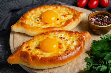 Ajarian Khachapuri, peynirle dolu ve yumurta sarısı ile kaplanmış, geleneksel Gürcistan Khachapuri peynirli ekmek ile Karanlık Kırsal Arka plan