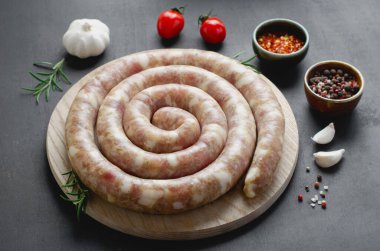 Geleneksel Çiğ Spiral Sosisler, Karanlık Arkaplanda Baharatlarla Etli Yuvarlak Sosisler