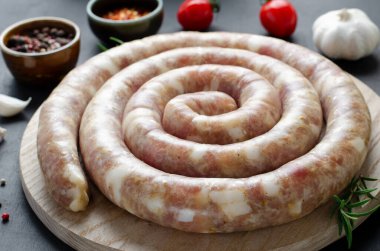 Geleneksel Çiğ Spiral Sosisler, Karanlık Arkaplanda Baharatlarla Etli Yuvarlak Sosisler