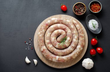 Geleneksel Çiğ Spiral Sosisler, Karanlık Arkaplanda Baharatlarla Etli Yuvarlak Sosisler