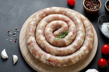Geleneksel Çiğ Spiral Sosisler, Karanlık Arkaplanda Baharatlarla Etli Yuvarlak Sosisler