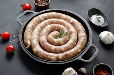 Geleneksel Çiğ Spiral Sosisler, Karanlık Arkaplanda Baharatlarla Etli Yuvarlak Sosisler