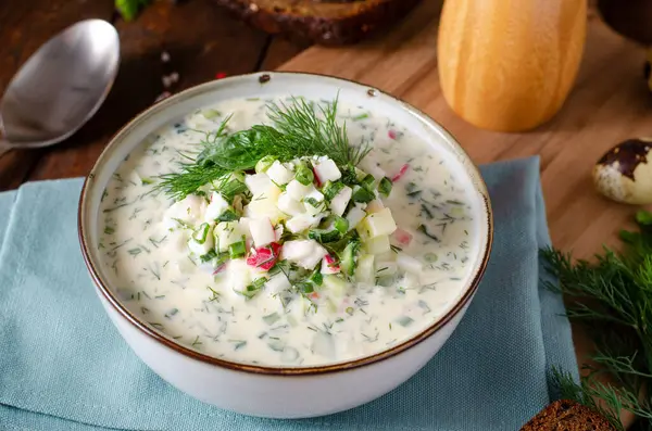 stock image Cold Okroshka Soup with Eggs, Vegetables, Meat, Herbs and Kefir on a Wooden Rustic Background, Summer Soup