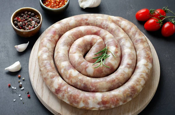 Geleneksel Çiğ Spiral Sosisler, Karanlık Arkaplanda Baharatlarla Etli Yuvarlak Sosisler