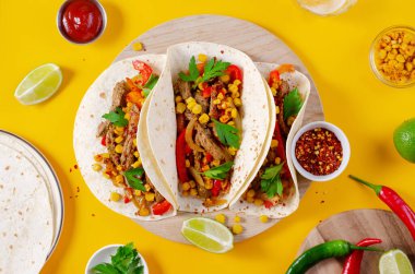 Meksika tacoları, sığır eti ve sebzeli, Tacos al Pastor, parlak sarı arka planda.