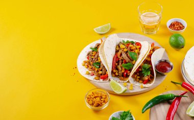 Meksika tacoları, sığır eti ve sebzeli, Tacos al Pastor, parlak sarı arka planda.