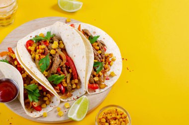 Meksika tacoları, sığır eti ve sebzeli, Tacos al Pastor, parlak sarı arka planda.