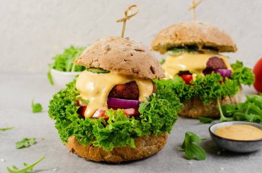 Sebzeli ve soslu lezzetli hamburgerler, Parlak Arkaplanda Bitkisel Köfteli Etsiz Burgerler