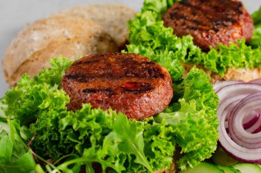 Taze ızgara Burger köfteleri, Bitkisel Köfteli Etsiz Burgerler Taze Marul ve Sebzelerle Parlak Arkaplanda Ahşap Tahtada