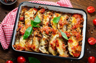 Patlıcan güveci, kıymalı kızarmış patlıcan tabağı, domates sosu ve ahşap arka planda Mozzarella.