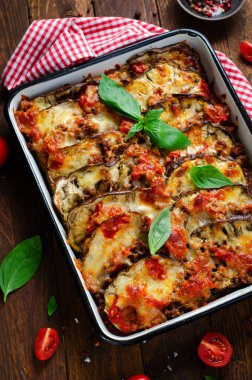 Patlıcan güveci, kıymalı kızarmış patlıcan tabağı, domates sosu ve ahşap arka planda Mozzarella.