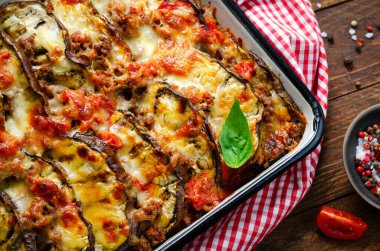 Patlıcan güveci, kıymalı kızarmış patlıcan tabağı, domates sosu ve ahşap arka planda Mozzarella.