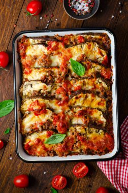 Patlıcan güveci, kıymalı kızarmış patlıcan tabağı, domates sosu ve ahşap arka planda Mozzarella.