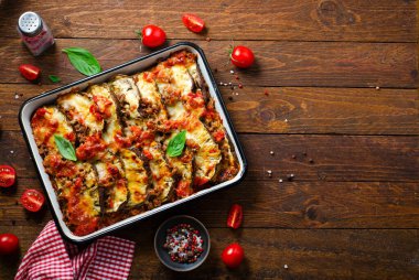 Patlıcan güveci, kıymalı kızarmış patlıcan tabağı, domates sosu ve ahşap arka planda Mozzarella.