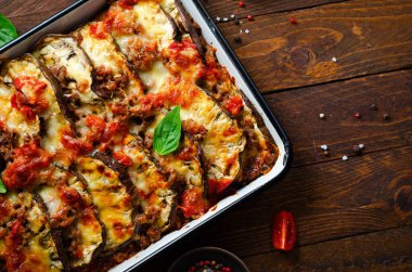 Patlıcan güveci, kıymalı kızarmış patlıcan tabağı, domates sosu ve ahşap arka planda Mozzarella.