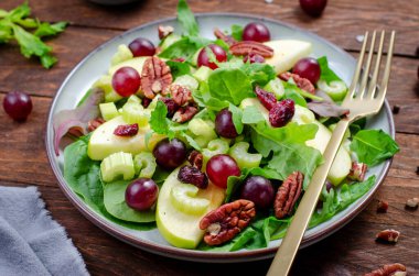 Waldorf Salatası, kızılcık, üzüm, kereviz, fındık ve salata karışımı, ahşap arka planda sonbahar salatası