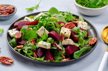Mavi peynirli pancar salatası, fındık ve salata karışımı. Parlak arka planda, lezzetli aperatif.